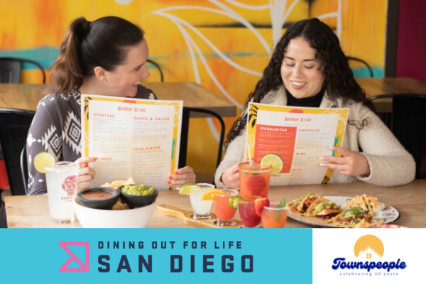 Promo graphic featuring a color photo of two femme-presenting people, seated and holding up menus in a colorful Mexican restaurant.