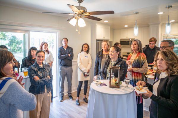Executive Director Melissa Peterman addresses a gathering of people in attendance of the Meade Avenue Housewarming.